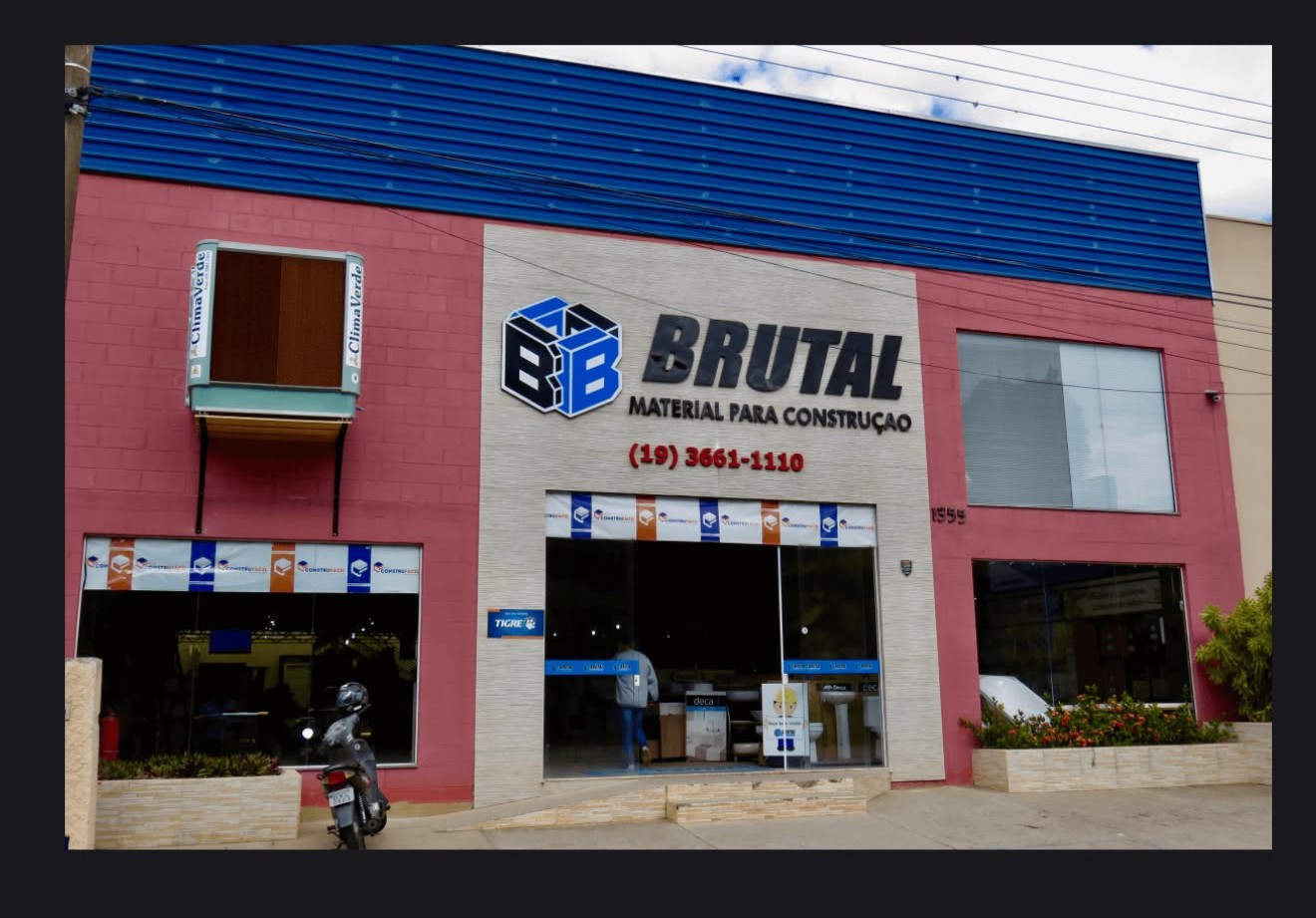 Fachada da loja Brutal Material para Construção no início dos anos 2000, com paredes vermelhas e telhado azul.